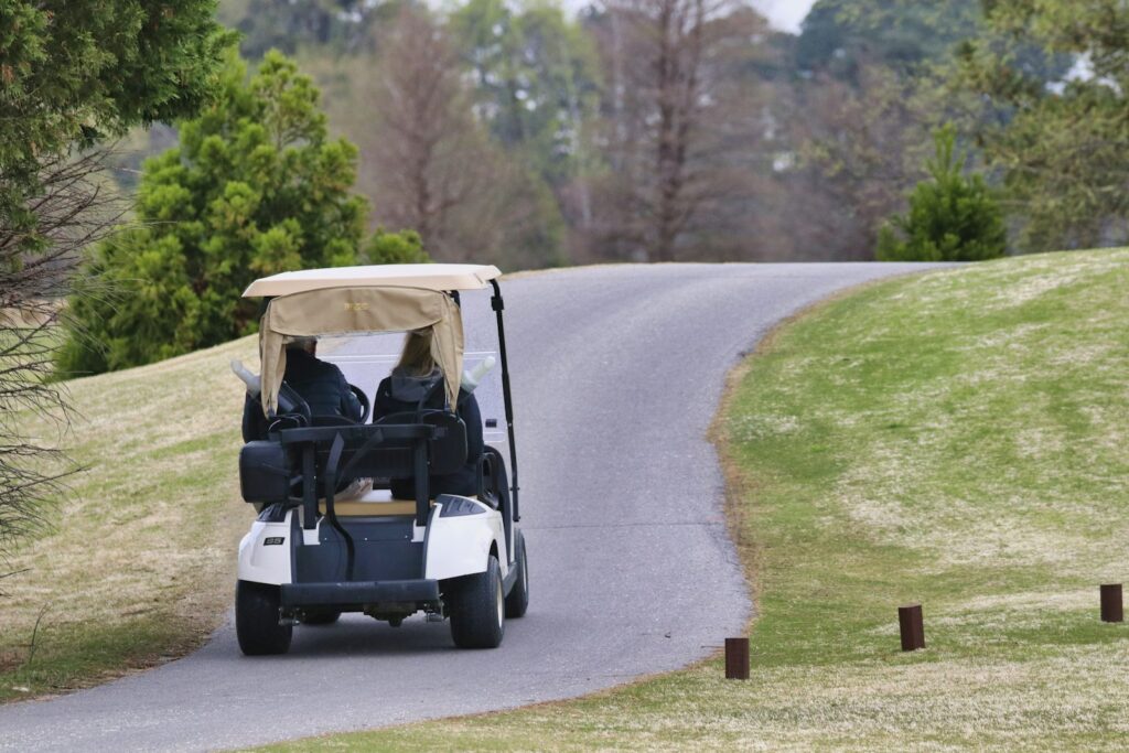 Buggy de golf circulando por el camino del campo