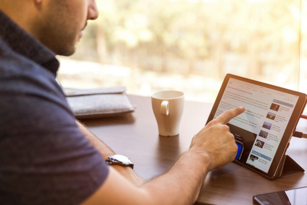 Blog de golf: persona leyendo artículos en una tablet con un café