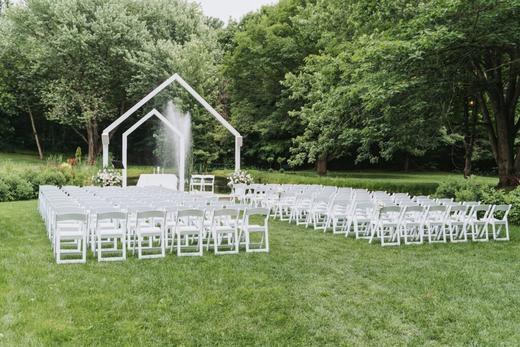 Bodas: montaje de ceremonia al aire libre con sillas blancas y arco