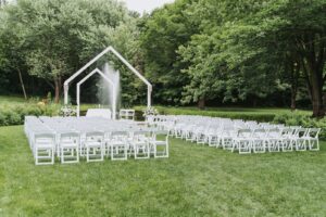 Bodas: montaje de ceremonia al aire libre con sillas blancas y arco