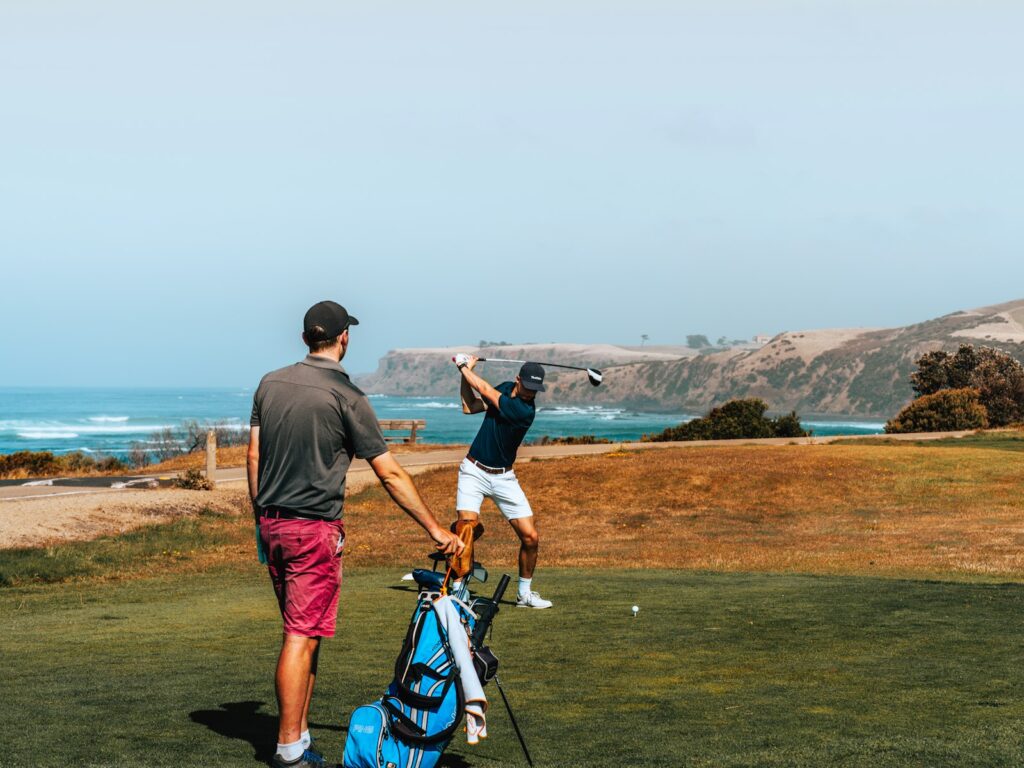 Golf academy: coach and student during a lesson by the sea