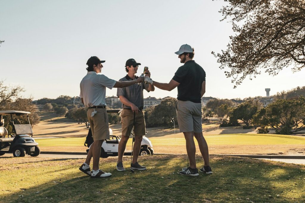 Tres golfistas brindando en el campo al final de la jornada