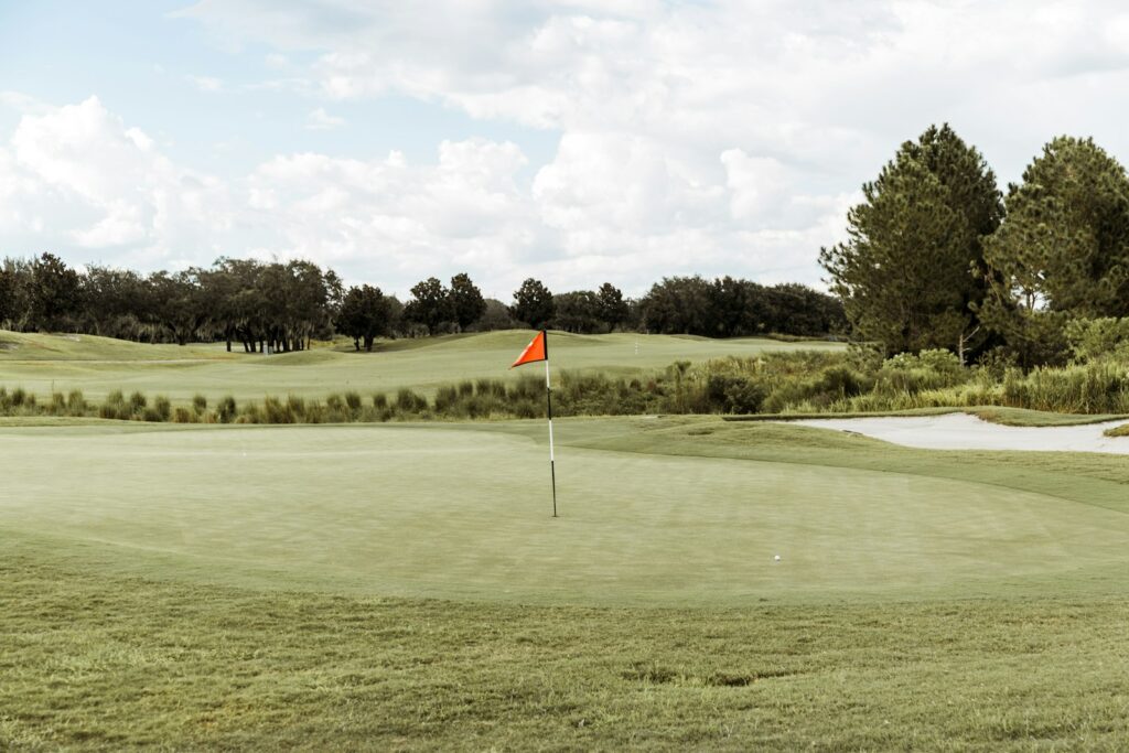 Green con bandera roja en un campo de golf